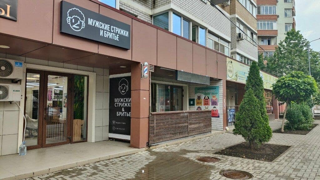 Фасад True Man Studio с вывеской «Мужские стрижки и бритьё»
